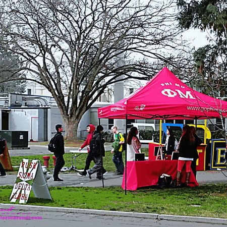 A bright pink tent beckons vibrant college students to explore leisure activities on campus.