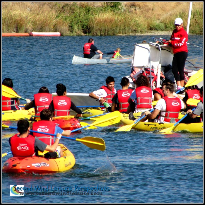 Students engage in dual kayaking for a leisure class.