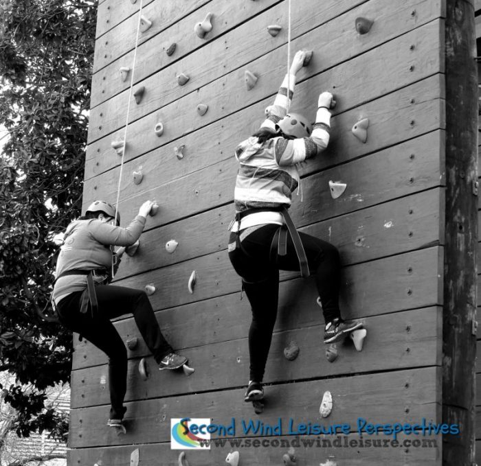Students carefully "walk" their feet on the climbing wall.