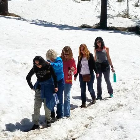 Hikers navigate a snow field in May