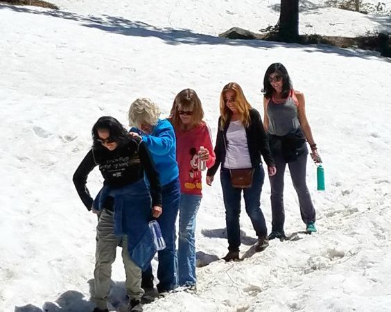 Hikers navigate a snow field in May