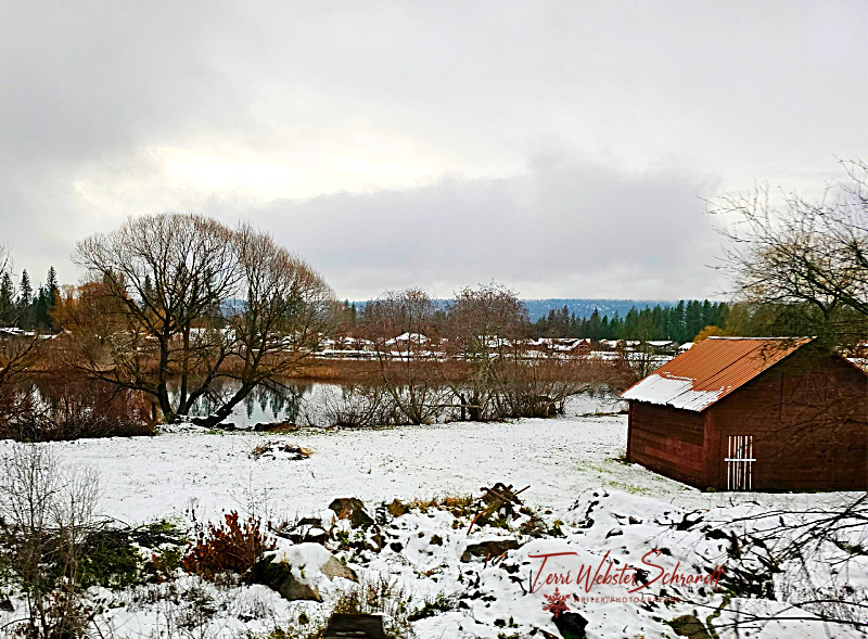 red barn in snow by a lake