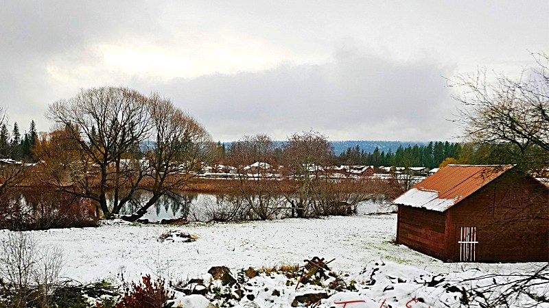 red barn in snow by a lake