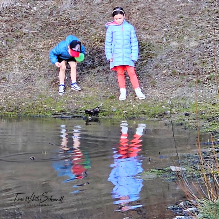 two children stand by water